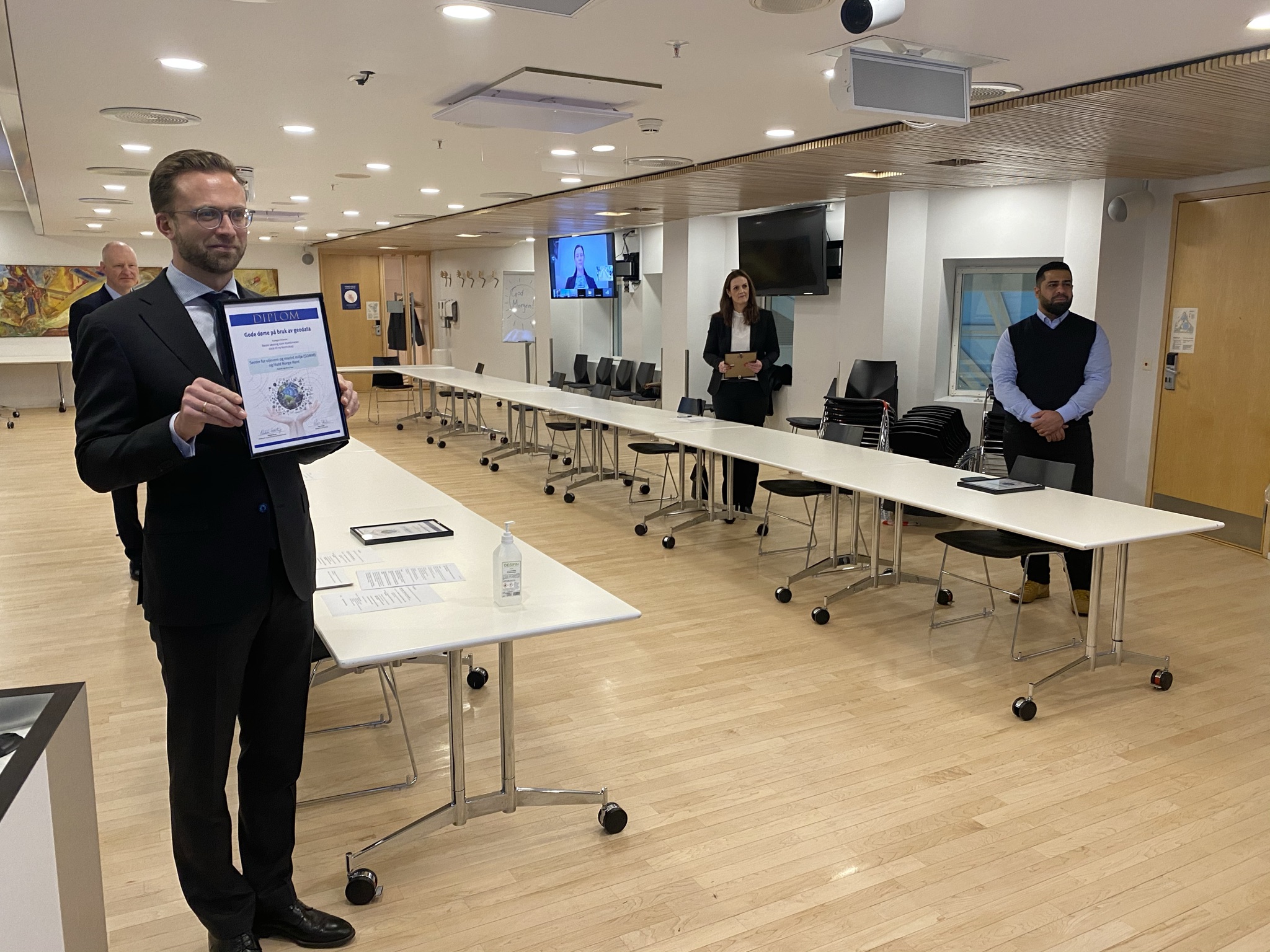 Kommunal- og moderniseringsminister Nikolai Astrup i m&oslash;terom syner fram diplomet til kamera