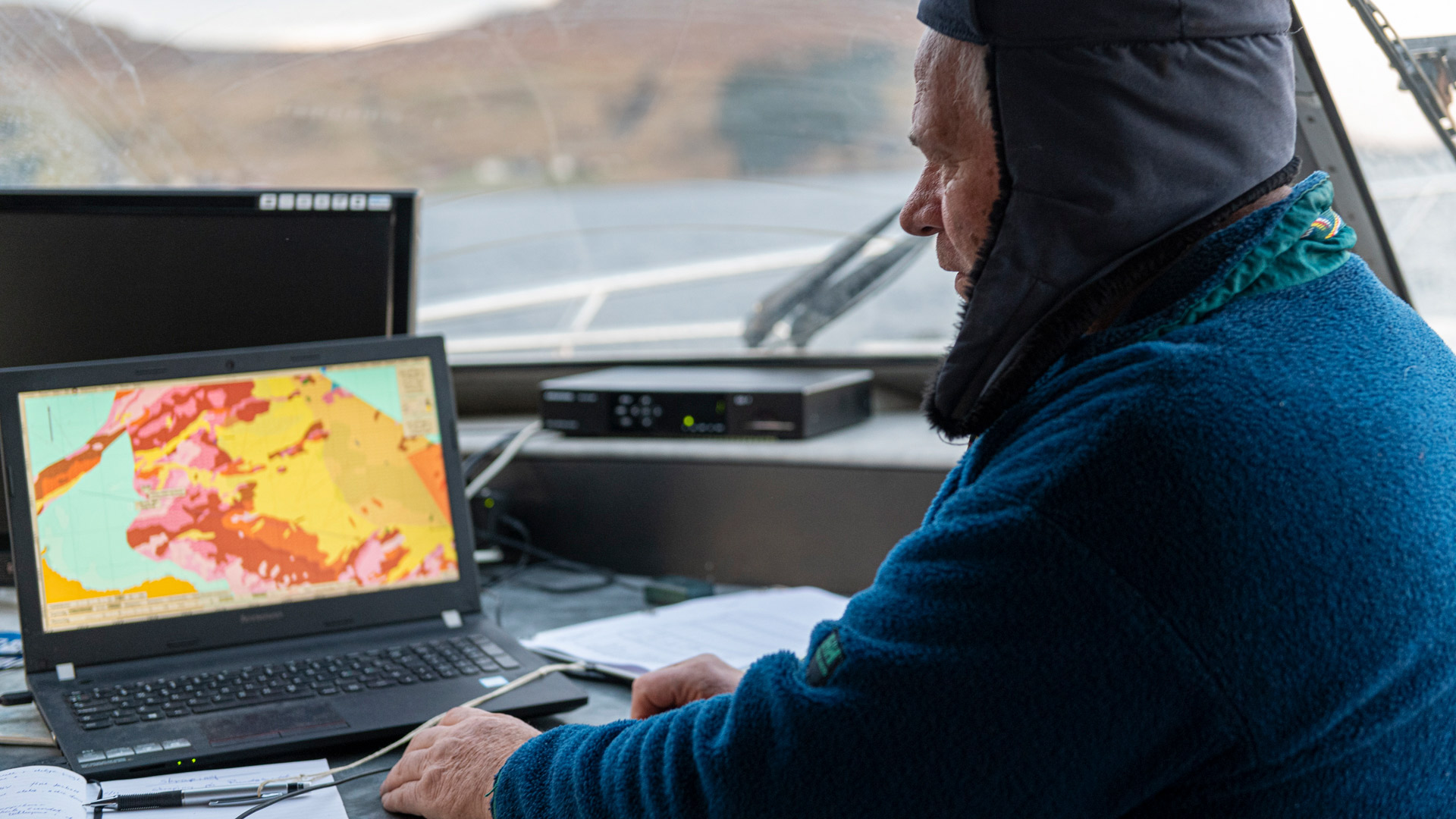 Mann om bord i en b&aring;t peker i sedimentkart vist p&aring; en PC. Foto: Nils Roar Hareide