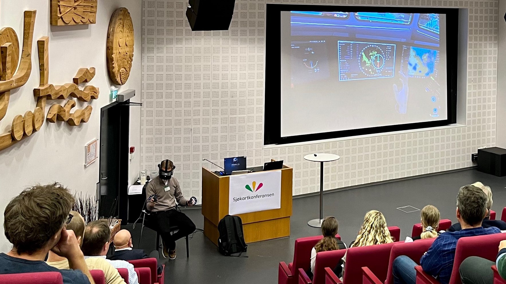 Odd Sveinung Hareide demonstrerer VR-briller brukt til &aring; trene statsloser. Foto.