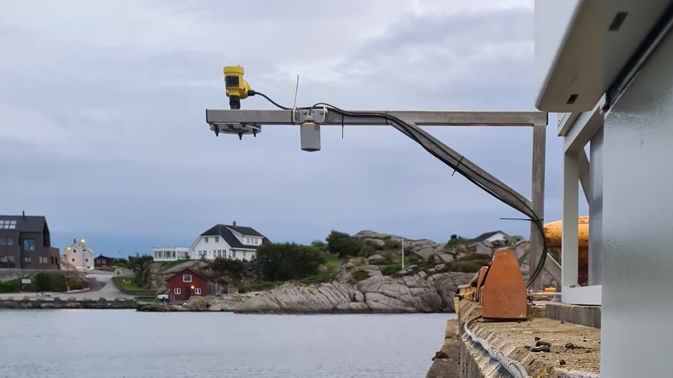 Permanent vannstandm&aring;ler er montert p&aring; ei kai i Sirev&aring;g p&aring; J&aelig;ren. Utsikt utover sj&oslash;en og bebyggelse p&aring; andre siden. Foto: Bj&oslash;rn Erik Bue