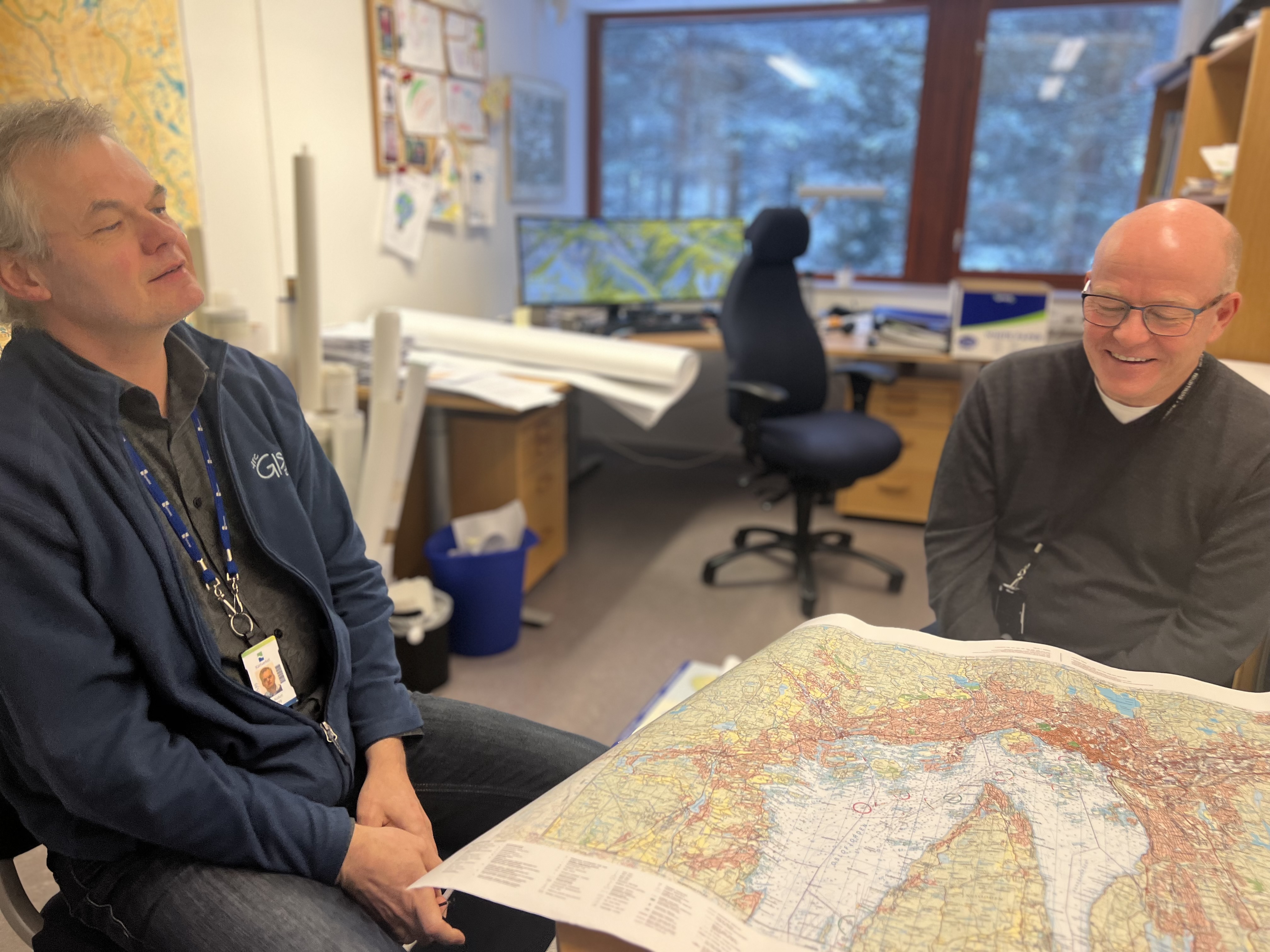 To ansatte ved Kartverket med et kart mellom seg